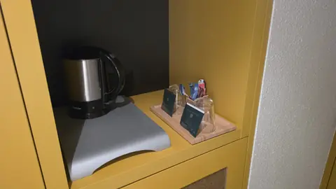 The kettle and the tray — the small mercies of a hotel room.