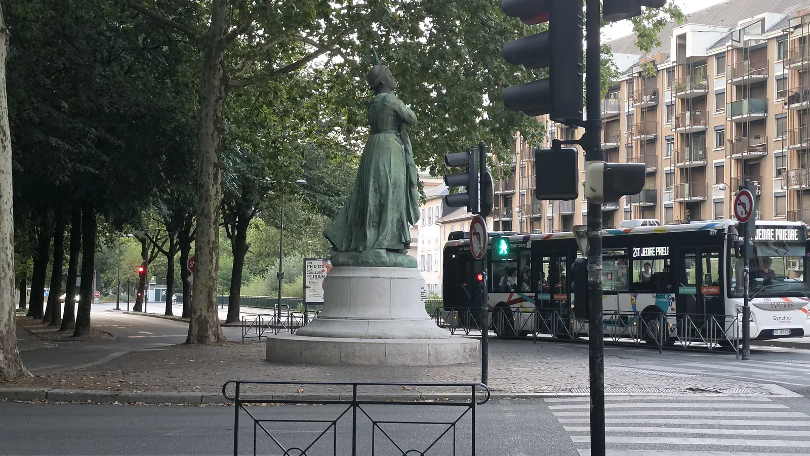 Back along the avenue, a statue and the last of the evening buses