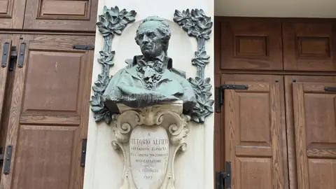 A bronze bust in a niche, between two doors.