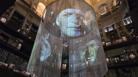 The hall under the dome, with films playing on the curved screens.