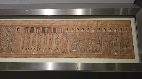The Book of the Dead, unrolled the length of the case.