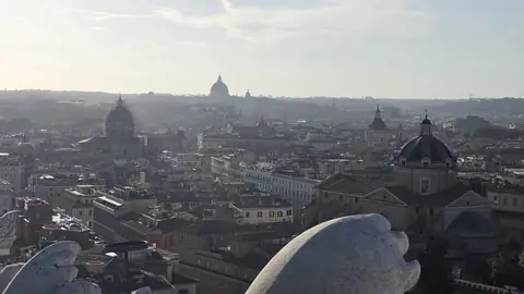 Domes, rooftops, and hills going off into the haze.