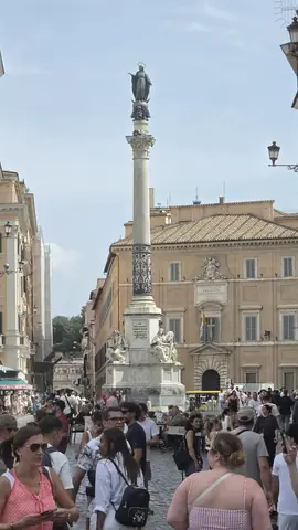 A column in the middle of the crowd, holding up a Madonna.