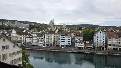 The city from the bridge: spires, water, cranes.